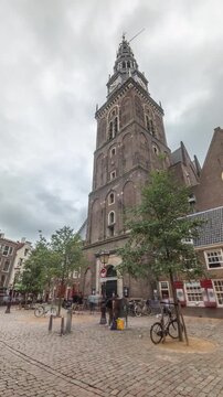 Hyperlapse of Amsterdam's Old Church (Oude Kerk), the city's oldest parish church, surrounded by historical houses in De Wallen district on Oudekerksplein timelapse. Iconic landmark in the Netherlands