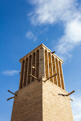 Historic windcatcher in Yazd, Iran, stands tall against a vivid blue sky—an iconic example of ancient Persian architecture and sustainable design.