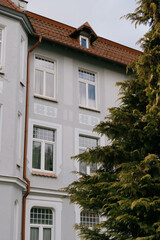 Historical architecture. modenrn. large building with a red roof and white trim. There are many windows in the building, including a large window on the facade.