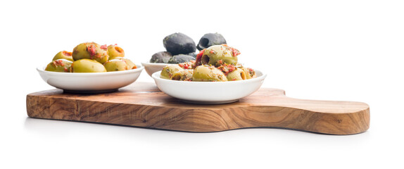 Tapas. Flavored pickled olives in bowl on cutting board isolated on white background.