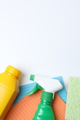 Top view with cleaning products including bottle, sponge, spray on white background. Flat lay...
