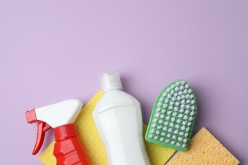 Flat lay cleaning concept. Cleaning products including brush, sponge, spray on color background....