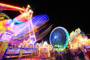 Colored rays of light produced by the attractions of a popular fair.