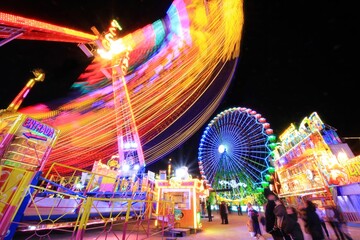 Colored rays of light produced by the attractions of a popular fair.