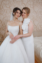 Bride and her friend pose together in a graceful moment before the wedding ceremony