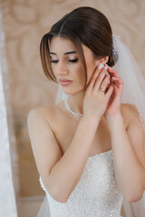 Bride prepares for her wedding ceremony in elegant bridal attire with detailed accessories