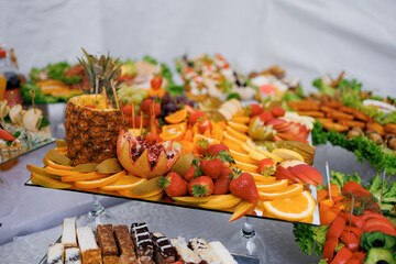 Delicious fresh fruit and assorted food display at a catered event in a tent setting