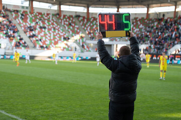 Team manager man shows players substitution during football match.