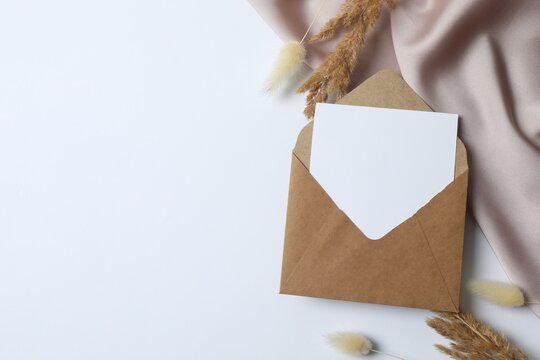 Paper envelope with dry flowerson white background.  Ideal for wedding invitations, event announcements