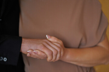 Couples share a tender moment while holding hands indoors during a warm afternoon