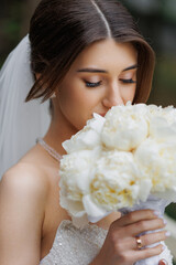 Bride holding bouquet while preparing for outdoor ceremony in soft natural light
