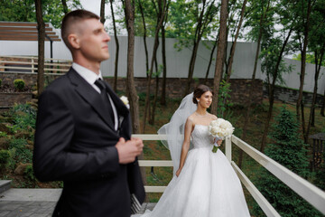 Elegant wedding couple preparing in a serene outdoor setting on a sunny day