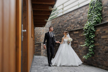 Couple walks hand-in-hand down stone pathway during their outdoor wedding ceremony