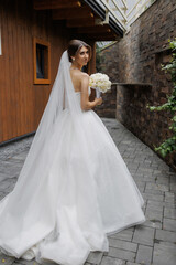 Elegant bride poses with bouquet in stunning outdoor setting during wedding ceremony