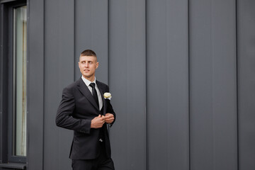 Young man in a formal suit preparing for a special event in an urban setting