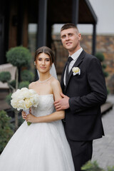 Wedding couple poses together outdoors during a bright day at a lovely venue