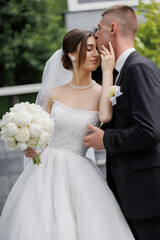 Couple shares a tender moment during their wedding ceremony in a beautiful garden setting