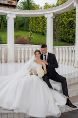 Couple poses together in outdoor wedding ceremony at scenic venue with lush greenery