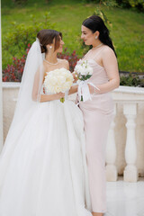 Two bridesmaids share a joyful moment during a wedding ceremony in an outdoor venue