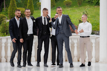 Friends celebrate together at an outdoor wedding ceremony in a scenic garden setting