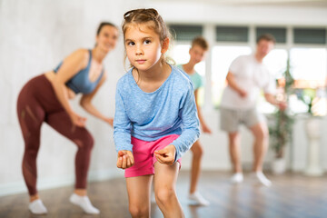 Parents with daughter and son practice dance moves in fitness class