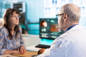 Senior skilled medic and woman patient engage in a medical consultation with diagnostic tools and x...