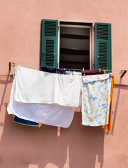 Washing Hanging Outside Pastel Coloured Fishing Village Houses On The Cliffs In Boccadasse, Genoa, Italy