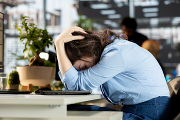 Young employee deals with emotional strain and frustration of business failure, disappointment and...
