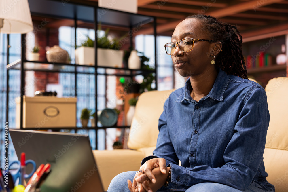 Poster woman focused on a workshop to learn new skills from her apartment, interacting with the tutor on on
