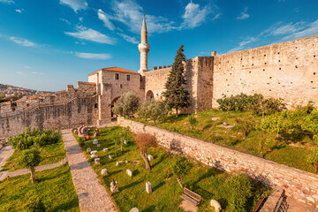 Cesme Castle with mosque minaret overlooking the Aegean Sea in Izmir province, Turkey, during a sunny summer day