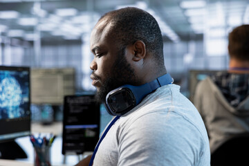 Software developer implementing cybersecurity measures to protect data center assets and...