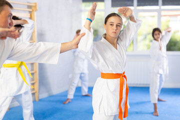 At single combat arts class, children learn basic techniques and positions. Teacher corrects pose...