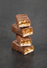 Chocolate Candy bar. Nougat, caramel with peanuts, in milk chocolat. Dark background. Close up