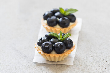 Blueberry tartlet. Light gray background. Top view