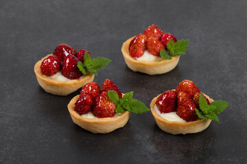 Vegan Mini strawberry tartlet. Dark background. Close up	