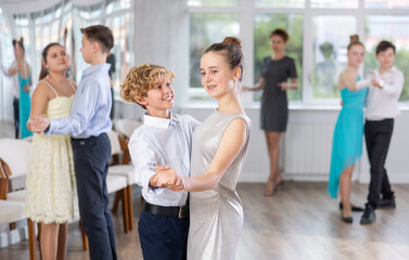 Happy interested teenage students preparing for college festive event, rehearsing ballroom dance...