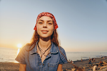 Lifestyle woman wearing modern boho-western denim street style outfit with a red bandana at sunset,...