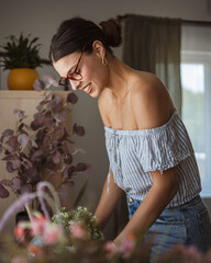 adult woman meticulously cleans dust from furniture in the living room