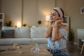 Smiling relaxed dark haired woman making anti-aging face massage