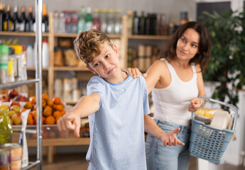 Disgruntled boy asks his mother to buy something from grocery store