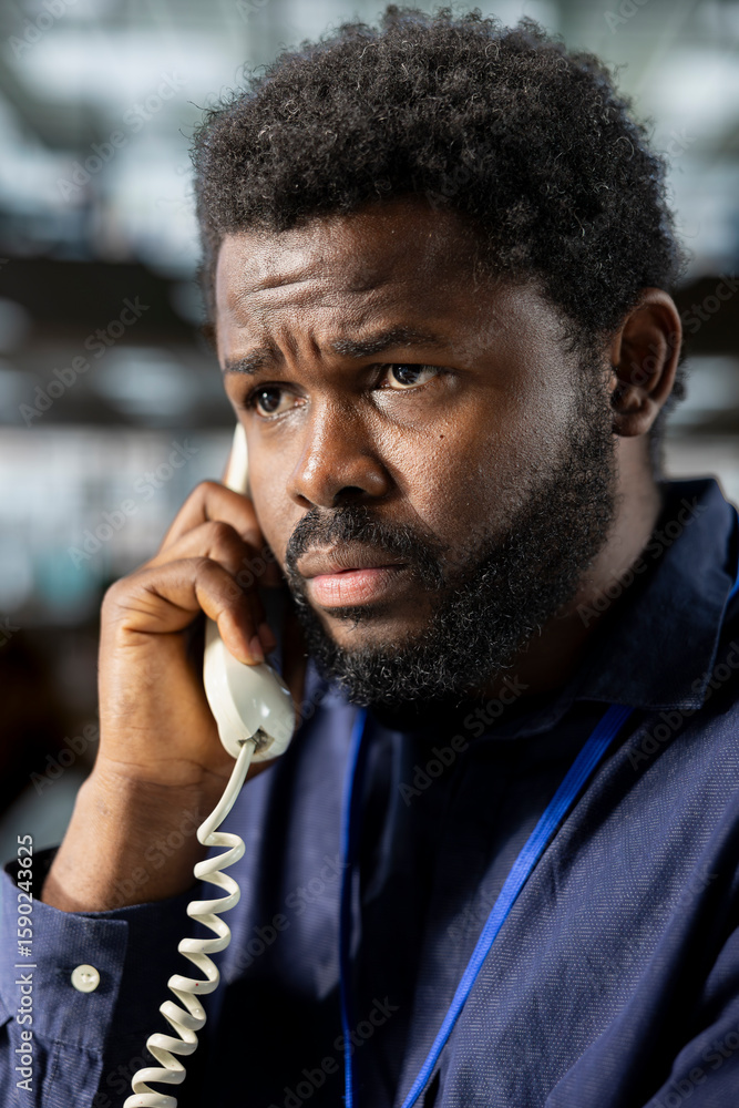 Aufkleber black corporate employee engages in a landline phone call at the office, managing a project briefing