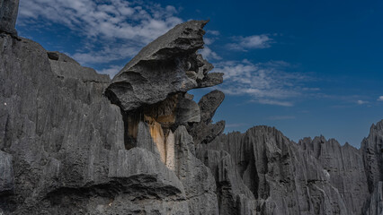 Unique karst rocks against a background of blue sky and clouds. Bizarre outlines, steep furrowed...