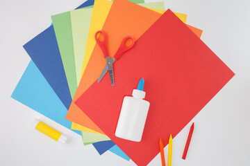 Stack of colored sheets and scissors isolated on clean background, ideal for office supply ads, stationery product shots, education visuals, print shops, and minimalist e-commerce catalogs,