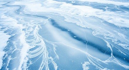 Aerial view of a frozen lake surface with intricate patterns of ice, cracks, and varying shades of blue and white.