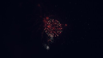 Colored night explosions in black sky. New years eve fireworks celebration. Glowing fireworks show....