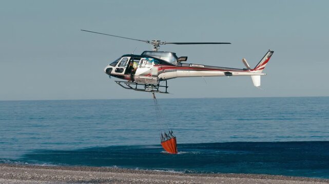 Helicopter collects water in the ocean 