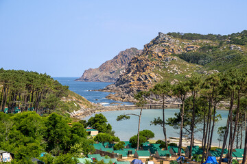Camping site at Cíes Islands in Vigo, Galicia, Spain, surrounded by turquoise sea and pine...