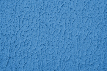 Close up of textured blue color painted wall with rough stucco, plaster wall texture. Vibrant background, wallpaper, backdrop, design element.