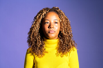 Young woman showing empowerment and beauty on purple background