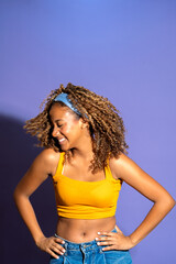Young woman smiling and dancing with purple background